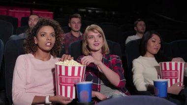 Canlı bir grup genç arkadaş, ekrandaki film karşısında büyülenen rahat bir multiplex tiyatrosunda oturuyor. Ellerindeki patlamış mısırla ve yüzlerindeki gülümsemeyle, ortak eğlencenin neşesini somutlaştırıyorlar, birlikte unutulmaz anılar yaratıyorlar.