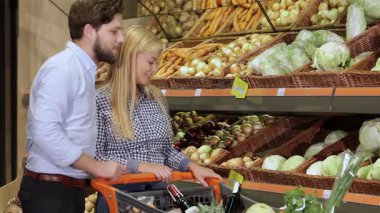 Tarz sahibi beyaz bir çift süpermarkette enfes bir alışveriş deneyimi yaşıyor. Çekici sarışın kadın taze bir lahanaya uzanırken erkek de düşünceli bir şekilde izliyor. Rengarenk sebzelerin bu canlı görüntüsü...