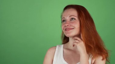 Göz kamaştırıcı kızıl saçlı genç bir kadın rüyasında uzaktan bakar. Yumuşak gülüşü sıcaklık ve mutluluk saçar. Canlı yeşil renkli bir arkaplan karşısında zarif bir şekilde poz vererek dinginlik ve güzellik duygusunu somutlaştırıyor, izleyicileri davet ediyor.