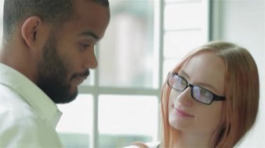 Parlak, modern bir klinikte, odaklanmış bir doktor, genç bir kadın hastayla analiz sonuçlarını dikkatlice tartışır, ilgili ve profesyonel bir atmosfer sergiler. Doktor, sakallı bir adam, hasta olarak dikkatle dinliyor, gözlüklü bir kadın.