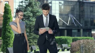 Şık takım elbiseli kendine güvenen bir işadamı ve şık giyinmiş başarılı bir iş kadını hareketli bir şehir sokağında bir tablet sergileyerek canlı bir tartışmaya girişirler. İfadeleri coşku ve profesyonelliği yansıtıyor.