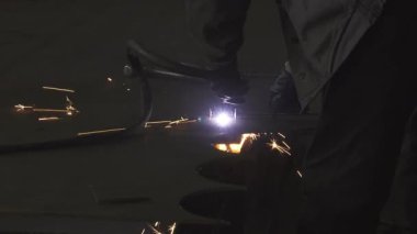 Koruyucu üniformalı odaklanmış bir endüstri çalışanı, bir plazma kesiciyi ustalıkla manevra ettiriyor ve çarpıcı bir şekilde kıvılcımlar saçıyor. Bu yoğun sahne, ağır metal işçiliğinin özünü yakalar. Hassasiyetini ve yeteneğini gösterir.