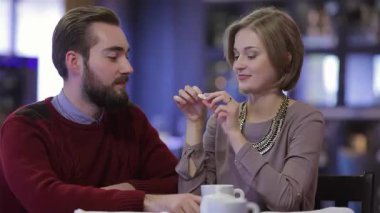 Sevimli genç bir çift, rahat bir kafede romantik bir buluşmadan zevk alır. Kahkahalarını içerken çay ve kahve içerler. Sevgiyi kutlarken samimi bağlantıları parlıyor, neşe ve sıcaklıkla dolu enfes bir atmosfer yaratıyorlar.