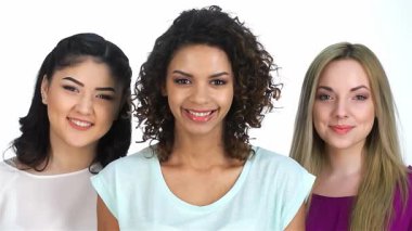 Üç çarpıcı kız, her biri eşsiz güzellikler sergiliyor, parlak beyaz bir arka plana neşeli öpücükler yolluyorlar. Bu canlı sahne, Asyalı, Kafkasyalı ve Afro-Amerikalı kadınların gülüp bir anı paylaştığı arkadaşlığın neşesini yansıtıyor.