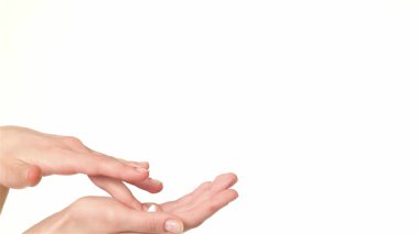 Yakın çekim beyaz bir kadını avuçlarına losyon sürerken yakalar ve narin parmaklarını hareket ettirir. Huzurlu beyaz arka plan, güzel ellerine odaklanmasını sağlar. Rahatlama ve kendine dikkat etme hissi verir.