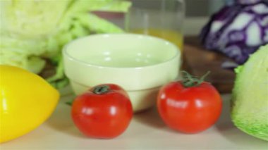 Canlı bir masa sulu domatesler ve parlak biberler de dahil olmak üzere taze sebzelerle süslenirken, genç arkadaşlar keyifle sıcak bir mutfakta yemek hazırlıyorlar. Sahne sıcaklığı ve dostluğu yansıtıyor, yemek pişirmenin heyecanını gösteriyor.