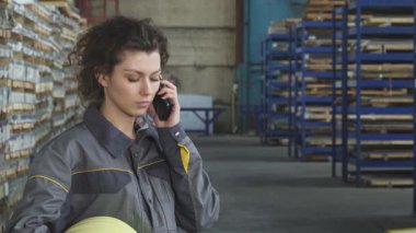 İki odaklanmış genç bayan fabrika işçisi canlı bir deponun organize kaosu arasında stok belgelerini dikkatle inceliyor. Ekip çalışmaları evrak işlerinde yol alırken, profesyonellik ve dinamik bağlılığı gösterirken parlıyor.