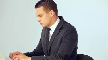 Sivri takım elbiseli genç bir erkek işadamı dizüstü bilgisayarındaki verileri dikkatle analiz ederek profesyonelliği ve kararlılığı somutlaştırıyor. Zarif ofis ortamı, hayati bir karar verirken üretkenlik ve hırs atmosferini arttırıyor.