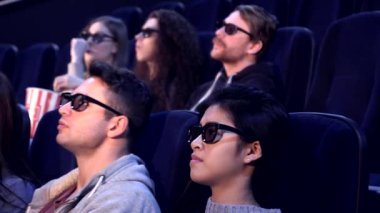 Üç boyutlu gözlük takan çeşitli genç yetişkinler sinemada büyüleyici görsel efektlere kapılıyorlar. Korku ve heyecan ifadeleri patlamış mısırı paylaşırken ve filmin heyecanını birlikte yaşarken heyecan verici bir atmosfer yaratıyor.