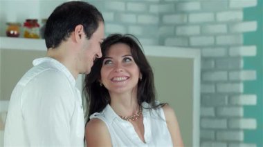 Sevgi dolu bir çift mutfakta bir anı paylaşır. Lezzetli bir yemek hazırlarken birbirlerinin gözlerinin içine bakarlar. Neşeli gülümsemeleri ve taze sebzelerin canlı renkleri sevgi dolu davetkar bir atmosfer yaratıyor.