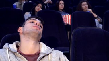 Kafkasyalı genç bir adam loş bir sinemada oturuyor, başını elinin üzerine yaslıyor, açıkça filme ilgi duymuyor. Arkasında, bir grup arkadaş, onun coşkusuzluğuyla onların kahkahalarını ve heyecanını karşılaştırarak, filmin tadını çıkarıyor.