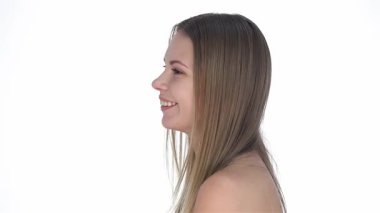 Dalgalı saçları olan hoş bir genç kız saf beyaz bir arka planda neşe saçarak saf güzellik ve kendine güven yayıyor. Taze, kusursuz teni ve büyüleyici gülüşü gençlik ve cilt bakımının özünü somutlaştırıyor.