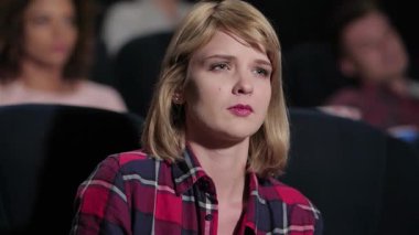 Çarpıcı mavi gözleri ve düşünceli bir ifadeyle genç bir kadın dikkatle izliyor, film kahramanlarının duygularını hissediyor. Sıcak bir tiyatroda arkadaşlarıyla çevrili olarak, patlamış mısır ve gazozdan hoşlanırlar, tamamen sinematik deneyime dalmışlardır.