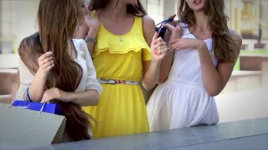 Her biri renkli alışveriş torbaları taşıyan üç modaya uygun kız, yeni elbiselerine hayran kalarak keyifli anları paylaşıyorlar. Işıl ışıl gülüşleri ve kaygısız kahkahaları bir günlük alışveriş için mükemmel bir dostluk ve eğlence ortamı yaratır.