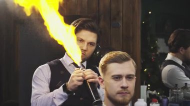 Yetenekli bir berber, müşterilerinin saçlarına dramatik bir yangın tedavisi uygular ve berber dükkanında heyecan verici bir atmosfer yaratır. Bu cesur teknik sadece saç stilini geliştirmekle kalmıyor, aynı zamanda modern sanatın ve cüretkar doğasının da gösterisini yapıyor.