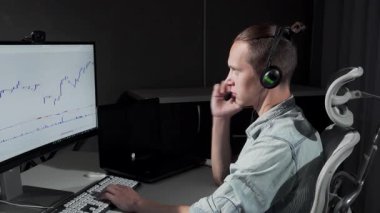 Kulaklık takan odaklanmış genç bir adam gece geç saatlerde bilgisayarında hisse senedi ticaretiyle çok meşgul. Loş ışıklandırma odası, modern girişimciliğin ve stratejik stratejinin özünü somutlaştıran karmaşık çizelgelerde gezinirken onun konsantrasyonunu vurguluyor.