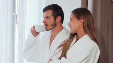 Neşeli bir çift pencereden dışarı bakar, rahat bornozlara sarılır, kahkahalar atar ve lüks otel odalarında tatlı fısıltılar fısıldar. Sıcak güneş ışığı perdelerin arasından süzülür. Sevecen gülümsemelerini aydınlatır. Romantik bir gülümseme yaratır.