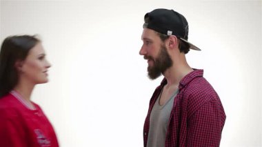 Canlı bir hippi çift, neşeli bir erkek ve kadın, yumuşak beyaz bir arka plana karşı tatlı bir öpücüğü memnuniyetle kucaklıyor ve paylaşıyorlar. Neşeli enerjileri sevgi ve mutluluk yayar, gençlik romantizmi ve bağlarını yakalar.