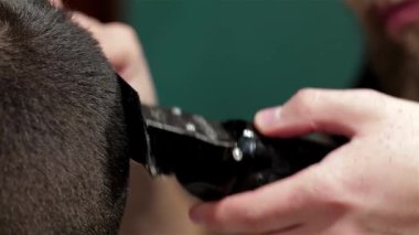 Profesyonel bir berber, şık bir berber dükkanında tımarcılık sanatını sergileyerek, bir müşterisinin saçını titizlikle kesiyor. Atmosfer modern yetenek ve klasik çekiciliğin bir karışımı ile dolu, berber dikkatle odaklanır.