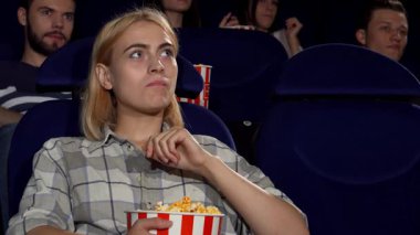 Sinemada heyecan verici bir film izlerken patlamış mısırın tadını çıkarırken düşünceye dalmış güzel bir genç kadının büyüleyici bir görüntüsü. Sinema salonunun hareketli atmosferi onun boş zamanlarını daha iyi değerlendiriyor, bu da onu mükemmel bir hafta sonu kaçışı yapıyor.