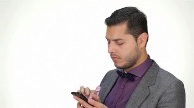 Sivri bir takım elbise ve papyon takmış şık genç bir işadamı, özgüven ve profesyonellik saçan cep telefonuna dikkatle odaklanıyor. Onun ciddi ifadesi modern iş hayatının özünü yakalıyor, teknoloji ve iletişimin