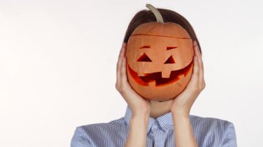 Güzel oyulmuş Cadılar Bayramı balkabağını tutarken kırmızı dudakları neşeyle parlayan neşeli bir kadın. Bu canlı sahne 31 Ekim kutlamalarının özünü yakalıyor. Mutluluk ve şenlik ruhu yayıyor.