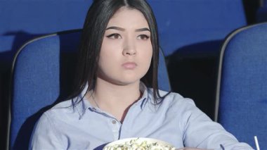 Asyalı bir kız pofuduk mavi bir sinema koltuğunda oturuyor. Yoğun bir film izlerken yüzünde sıkıntı ifadesi var. Patlamış mısır ve gazozdan hoşlanan arkadaşlarla çevrili atmosfer duygularla dolu, sinemanın heyecanını vurguluyor ve