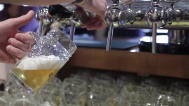Yetenekli bir barmen, buzlu bardağa çıtır çıtır bir bira dökerek mükemmel bir köpük kafası oluşturur. Hareketli barın canlı atmosferi, bu ferahlatıcı anın heyecanını arttırır. Müşterileri soğuk bir içkinin tadını çıkarmaya davet eder.