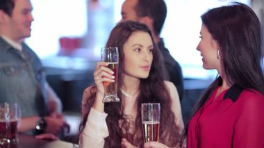 Barda, iki tatlı kızın kutlama için kadehlerini havaya kaldırarak animasyon sohbetlerine daldıkları canlı bir sahne başlıyor. Arkadaşlar en sevdikleri futbol takımına tezahürat yapmak için toplanırken, hareketli atmosfer heyecanla uğulduyor.