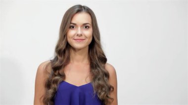 Neşeli genç bir kadın temiz beyaz bir arka plana karşı heyecan ve neşe saçarak kız kardeşlerinin gözlerini şakayla kapar. Kahkahaları havayı dolduruyor, samimi bir kardeş sevgisi ve neşeli bir sürpriz anı yakalıyor.