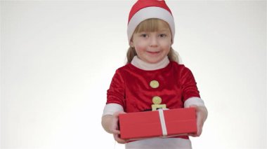 Neşeli bir Noel Baba kıyafeti giymiş hoş bir genç kız canlı kırmızı bir hediye kutusu sunarken neşe saçıyor. Neşeli ifadesi ve rahat stüdyo arkaplanı, tatil sezonunun sihrini çağrıştırıyor ve herkesi festivale davet ediyor.