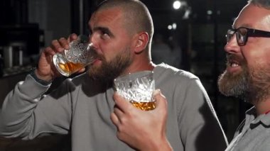 İki çekici erkek, heyecan verici bir futbol maçına dalmışken kutlama için bardaklarını kaldırarak bir viski barında keyifli bir anı paylaşıyorlar. Atmosfer elektriklidir, yoldaşlıkla doludur ve viskinin zengin kokusu mükemmel bir karışım yaratır.