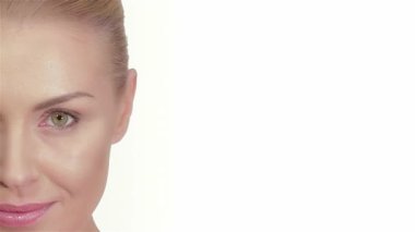 Bu çarpıcı yakın plan, beyaz tenli güzel bir kadının kameraya usulca bakışını gösteriyor. Nazik gülüşü ve mükemmel bakımlı yüz hatları saflık ve zarafet saçıyor, hayranlık uyandırıyor ve dingin bir güzellik hissi uyandırıyor.