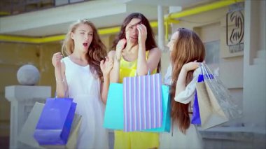 Her biri canlı alışveriş torbaları taşıyan üç modaya uygun kız butiklerle dolu şık bir cadde boyunca heyecanlı bir şekilde yürüyorlar. Işıl ışıl gülüşleri ve neşeli pozları arkadaşlığın ve tasasız alışveriş maceralarının özünü yakalar, hayat dolu bir alışveriş macerası yaratır.
