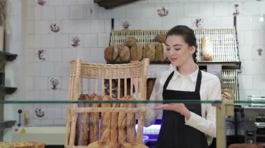 Neşeli genç bir fırıncı gururla cam bir ekranın arkasında duruyor, altın, kabuklu baget dolu bir sepeti sergiliyor. Taze pişmiş gıdaların davetkar aroması, gülümseyen kadının hoş bir seçim sunduğu sıcak kahve dükkanını doldurur.