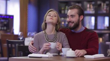 Sevimli genç bir çift romantik bir sevgililer günü yemeğinin tadını çıkarıyor. Sıcak bir restoran ortamında kahve ve çay yudumluyorlar. Yumuşak ışıklandırma ve zarif dekor ile vurgulanan sıcak ortam, gülümsemeleri paylaşırken şefkatli bağlantılarını geliştirir ve