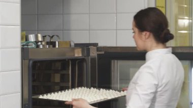 Gıcır gıcır beyaz bir üniforma giymiş yetenekli genç bir pasta şefi kendinden emin bir tepsi kremayı ışıldayan bir fırına koyar. Sıcak, davetkar mutfak, yaratıcılığı ve pişirme tutkusunu yayıyor, kendini işçiliğe adadığını gösteriyor.