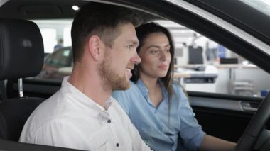 Neşeli, sakallı, beyaz bir adam galeride yepyeni bir arabanın içinde coşkulu bir şekilde sevinçten havalara uçuyor. Çekici esmer kız arkadaşı yanında oturuyor. Bu dönüm noktasını kucakladıklarında ikisi de sevinçle parlıyor.