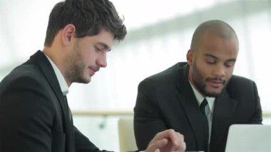 İki kendine güvenen iş adamı, biri siyah saçlı, diğeri de kafası tıraşlı, şık bir ofis masasında canlı bir tartışmaya giriyorlar. Modern dekorlarla çevrelenmiş fikir ve stratejileri paylaştıkça ifadeleri pozitiflik ve takım çalışması yayıyor.