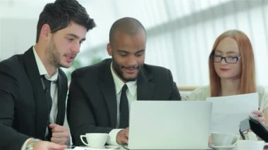 Dört hevesli genç profesyonelden oluşan bir grup, geniş pencerelerden yayılan doğal ışıkla aydınlatılmış gösterişli bir konferans masasının etrafında canlı bir tartışmaya girişiyor. Gülüşleri ve hareketleriyle takım çalışmasının canlı atmosferini yansıtıyorlar.