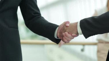 Parlak ve modern bir ofiste, iki işadamı güven ve işbirliğini simgeleyen sıkı bir tokalaşmaya girişirler. Gülüşleri, takım çalışmasının ve profesyonel başarının özünü yansıtan olumlu bir atmosferi yansıtıyor.