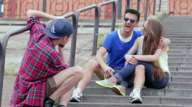 Üç genç arkadaş gülüşlerini ve gülüşlerini açık havada oturup, saf bir neşe anı yakaladılar. Titreşimli atmosfer dostluk ve kaygısız yaz titreşimleriyle doludur. Birlikte kalıcı anılar yaratırlar.