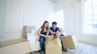 Aşık neşeli bir çift, karton kaplarla çevrili, parlak, boş evlerindeki kutuları hevesle açıyor. İfadeleri, yeni hayatlarını keşfederken mutluluk saçıyor. Sevgi ve beklentiyle dolu rahat bir yer yaratıyorlar.