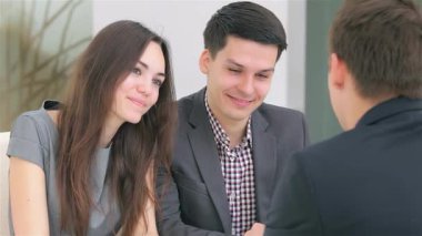 Genç ve çekici bir çift, modern ofis ortamında takım çalışması ve coşku sergileyen iş projeleri müdürüyle canlı bir tartışmaya girişiyor. Parlak, havadar ortam, strateji oluştururken odaklanmış ifadelerini geliştirir.