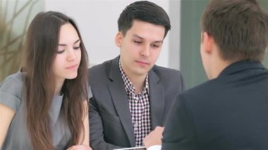 Genç ve çekici bir çift, şık bir ofis masasında oturan yenilikçi iş projeleri üzerine odaklanmış bir tartışmaya girişiyor. Atmosfer, laptoptaki verileri analiz ederken, kahveyi yudumlarken yaratıcılık ve hırsla dolu.