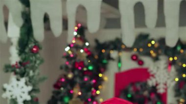 Sıcak süveter ve eşarplara sarılı sevgi dolu bir çift, parıldayan ışıklar ve canlı bir ağaçla süslenmiş bir Noel odasında hediyeler tutuyor. Şefkatli gülümsemeleri sıcaklığı ve mutluluğu yayarak büyülü bir atmosfer yaratıyor.