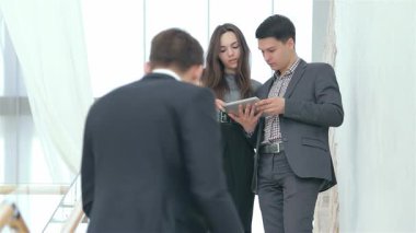 Genç profesyonellerden oluşan dinamik bir grup, modern bir ofis ortamında takım çalışması sergileyerek analiz ve tartışmayla derinden ilgileniyor. Ön planda, elinde defter olan odaklanmış genç bir adam gözlemlerken, genç bir çift yakın işbirliği içinde