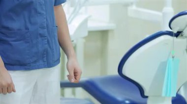 Neşeli bir hasta, parlak, iyi donanımlı bir dişçi ofisinde dişçiyle el sıkışıyor. Güven ve profesyonellik saçıyor. Sahne diş bakımının özünü yakalıyor. Gelişmiş aletlerle dolu bir karşılama atmosferi sergiliyor.