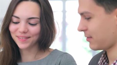 Bir tabletteki verileri analiz ederken genç, çekici bir iş adamının ve kadının büyüleyici yakın çekimi derin bir tartışmaya girdi. Kadınların ışıl ışıl gülüşü ve erkeklerin odaklanmış ifadesi bir takım çalışması ve yenilik ortamı yaratır.