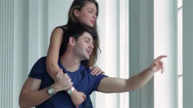 Neşeli bir çift, yeni dairelerinin penceresinde durur. Kız, sırtına neşeyle tünemiş bir şekilde gülümsemelerini ve heyecanlarını paylaşırlar. Elleri dışarıdaki manzaraya doğru hareket ediyor. Yeni başlangıçların heyecanını ve sıcaklığı simgeliyor.